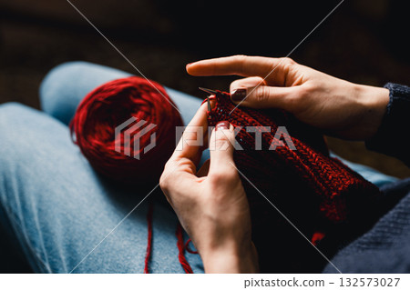 Cozy Knitting Session With Red Yarn: Hands Crafting A Warm Scarf For Relaxation And Home Comfort 132573027