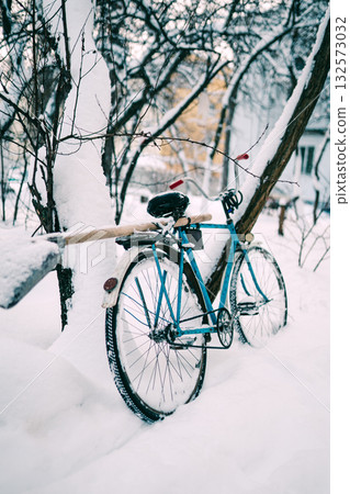 Blue Bicycle Leaning Against Snowy Tree in Quiet Winter Yard Exterior Scene Blue Bicycle Leaning Against Snowy Tree in Quiet Winter Yard Exterior Scene 132573032