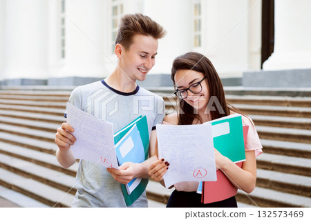 Female student brags her results of the test with male friend. Happy students received A grade for their final examination Female student brags her results of the test with male friend. Happy students received A grade for their final examination 132573469