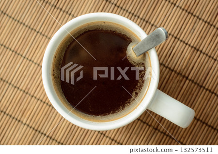 Top view of white cup with black coffee on a table Top view of white cup with black coffee on a table 132573511