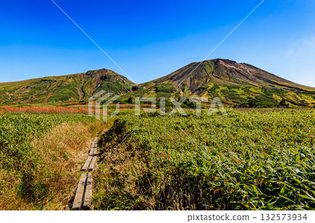 Walking through the autumn leaves of Mount Daisetsu - Looking out at the endless mountain ranges Walking through the autumn leaves of Mount Daisetsu - Looking out at the endless mountain ranges 132573934