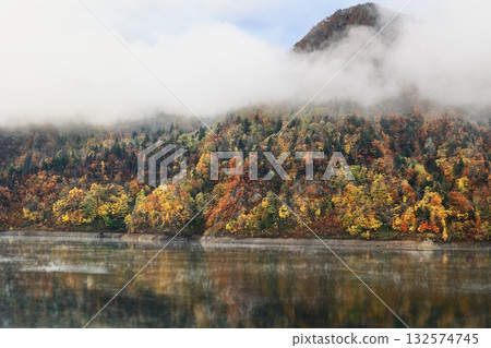 A mountain of autumn leaves filled with clouds A mountain of autumn leaves filled with clouds 132574745