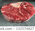 Side view of a raw beef shank steak with visible bone, placed on a dark stone countertop. High-resolution image with juicy texture, perfect for recipes, food blogs, packaging and culinary stock. 132574827