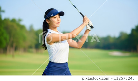 A woman finishing her golf swing A woman finishing her golf swing 132575243