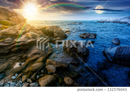 beautiful view of rocky sea coast under dramatic sky. day and night time change concept. scenic summer solstice landscape of beach under sun and moon at twilight. coastal background with large stones 132576043