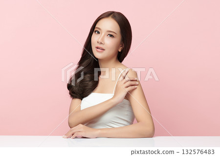 A beautiful young Asian woman with clean, fresh skin against a pink background. Skincare, facial treatment, cosmetology, beauty, and spa. An elegant portrait of an Asian woman. A beautiful young Asian woman with clean, fresh skin against a pink background. Skincare, facial treatment, cosmetology, beauty, and spa. An elegant portrait of an Asian woman. 132576483