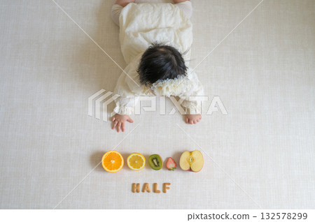 6-month-old baby with fruit on half birthday 132578299