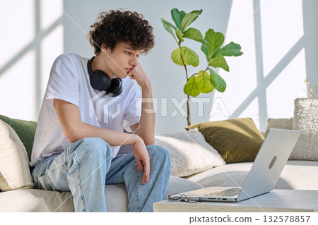 Young man using laptop for video call, online chat conference sitting at home Young man using laptop for video call, online chat conference sitting at home 132578857