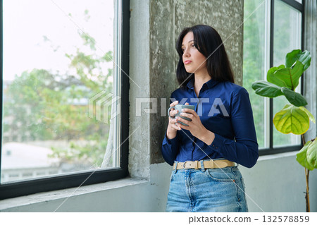 Serious tired, stressed businesswoman standing near window 132578859