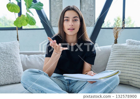 Webcam view of teenage girl student with textbook studying online remotely, video lesson Webcam view of teenage girl student with textbook studying online remotely, video lesson 132578900