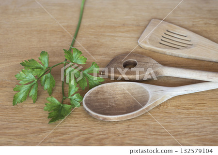 Wooden kitchen stirrers with sprig of green parsley Wooden kitchen stirrers with sprig of green parsley 132579104