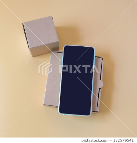 A smartphone placed on a brown paper box,technology and packaging concept. A smartphone placed on a brown paper box,technology and packaging concept. 132579541