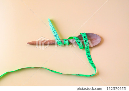 A Measuring tape for tying wood spoon,diet, healthy lifestyle concept. 132579655