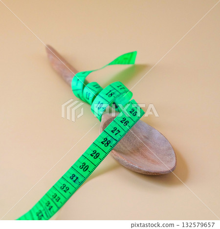 A Measuring tape for tying wood spoon,diet, healthy lifestyle concept. 132579657