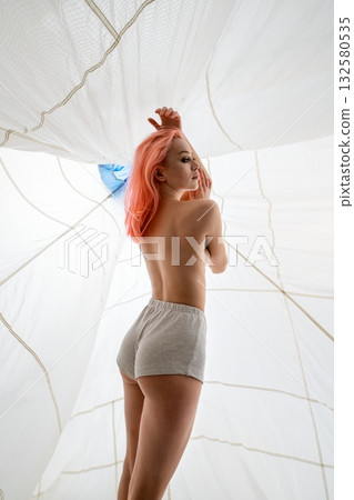 Young Woman With Pink Hair Posing Underneath White Fabric Young Woman With Pink Hair Posing Underneath White Fabric 132580535