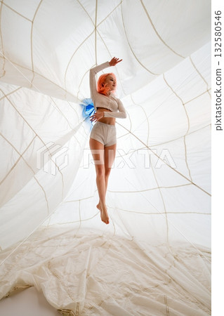 Young Woman With Pink Hair Suspended In A White Parachute 132580546
