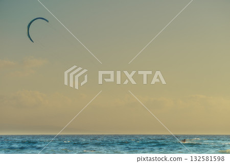 Kite surfer riding waves. Kiteboarding sport. 132581598