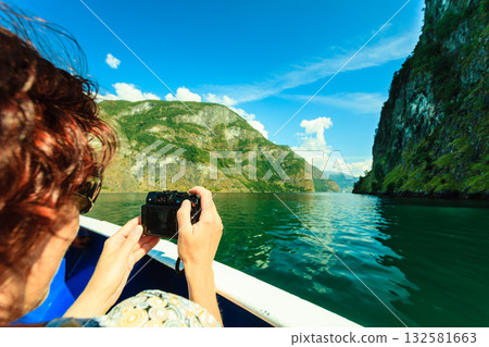 Tourism. Woman with camera on ship, fjord in Norway. 132581663
