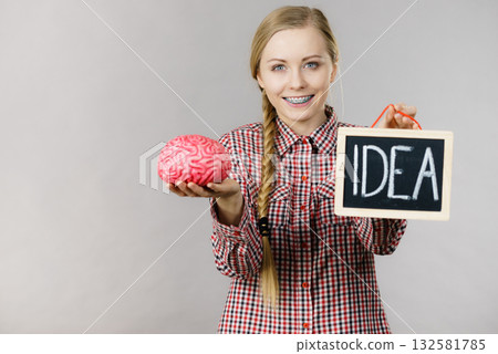 Woman holding idea sign and brain 132581785