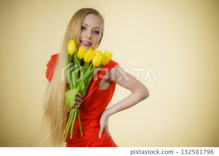Pretty woman with yellow tulips bunch 132581796