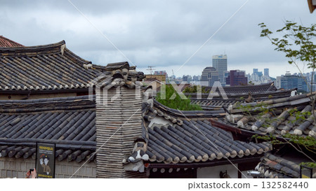 Bukchon Hanok Village rooftops contrasting modern Seoul cityscape Bukchon Hanok Village rooftops contrasting modern Seoul cityscape 132582440