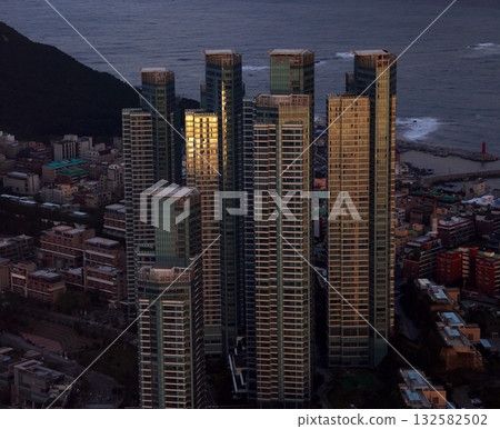 Busan tall buildings reflecting sunset light near ocean Busan tall buildings reflecting sunset light near ocean 132582502