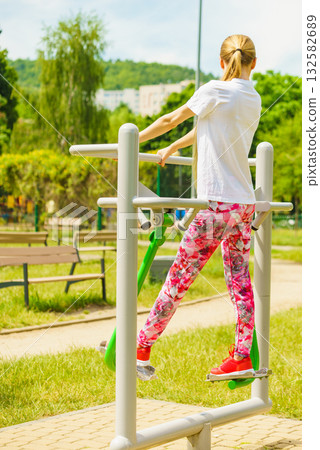 Woman doing exercise in outdoor gym 132582689