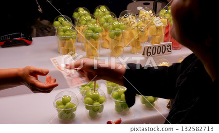 Paying for fruit in a Seoul street market Paying for fruit in a Seoul street market 132582713
