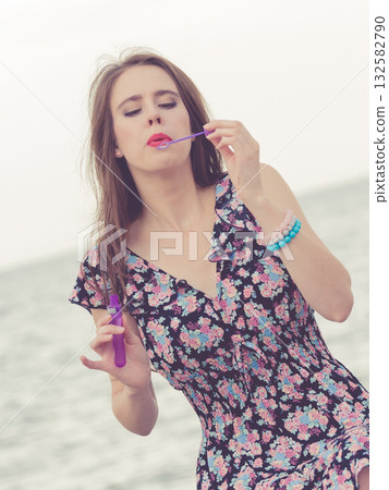 Woman blowing bubbles outdoor 132582790