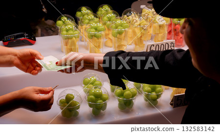 Buying fresh fruit cups at Seoul street market 132583142