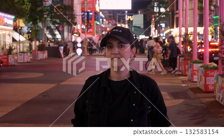 Woman traveler posing in vibrant Seoul street at night 132583154