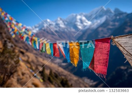 Colorful Himalayan prayer flags wave in a travel landscape below snowy mountains. Colorful Himalayan prayer flags wave in a travel landscape below snowy mountains. 132583663