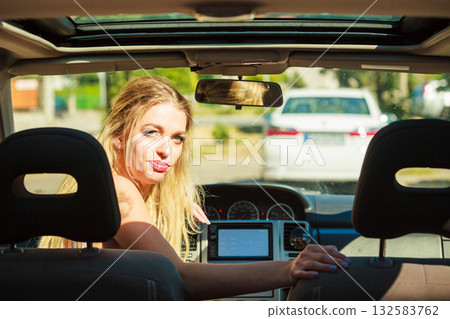 Woman in car looking back Woman in car looking back 132583762