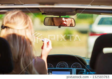 Girl apply make up while driving car. Girl apply make up while driving car. 132583763