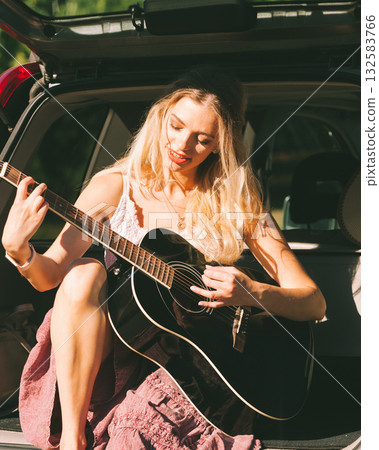 Girl with guitar on hatchback car Girl with guitar on hatchback car 132583766