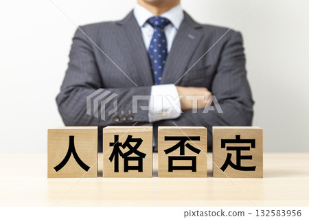 A businessman with his arms crossed and a block that reads "Denial of Personality" 132583956