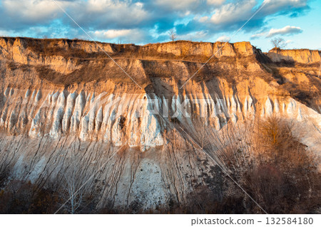 Evening photo of a chalk cliff. Chalk quarry, high almost vertical wall of chalk 132584180