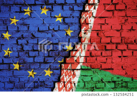 Cracked brick wall with flags of European Union and Belarus. Crisis in relationship between countries, problem of migrants and refugees on border 132584251