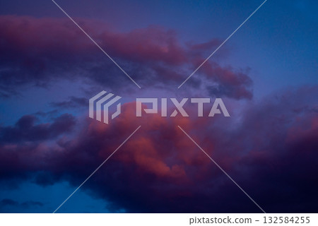 Dramatic vibrant cloudscape in the evening. Dark purple clouds lit by last rays of sun in late evening 132584255