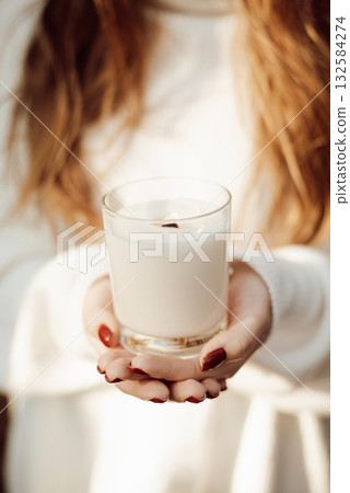 Close-up shot of a girl holding white burning candle. Aromatherapy with a candle Close-up shot of a girl holding white burning candle. Aromatherapy with a candle 132584274