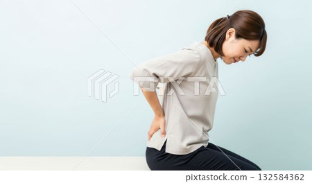 一位女士因腰痛而露出痛苦的表情。 132584362