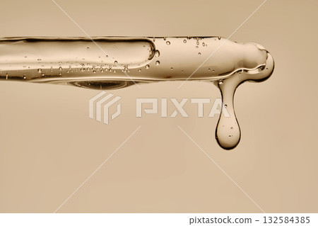 The texture of the hyaluronic serum flowing down the dropper. 132584385