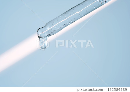 A serum pipette with lots of bubbles on a blue background. A serum pipette with lots of bubbles on a blue background. 132584389