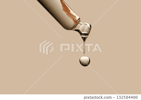 Serum in a pipette close-up on a beige background. 132584400