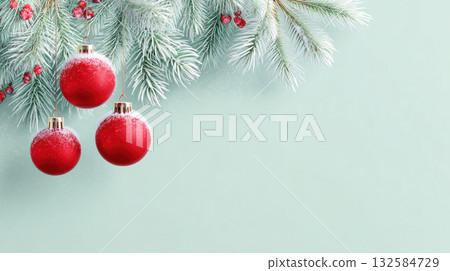 Festive red Christmas ornaments hanging from frosted evergreen branches against a soft mint green background, creating a cheerful holiday atmosphere Festive red Christmas ornaments hanging from frosted evergreen branches against a soft mint green background, creating a cheerful holiday atmosphere 132584729