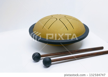 Golden Tongue Drum with Wooden Mallets on White Background Golden Tongue Drum with Wooden Mallets on White Background 132584747