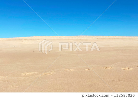 Sand dunes and blue sky on a sunny day. Natural background Sand dunes and blue sky on a sunny day. Natural background 132585026
