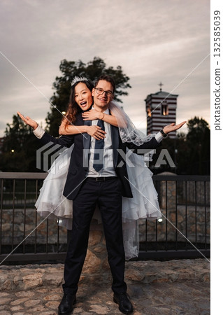 Interracial wedding couple celebrating love and happiness outdoors 132585039