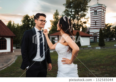 Bride playfully touching groom's chin at their wedding Bride playfully touching groom's chin at their wedding 132585044