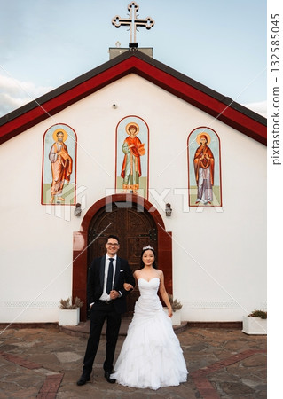 Interracial couple celebrating wedding outside orthodox church 132585045